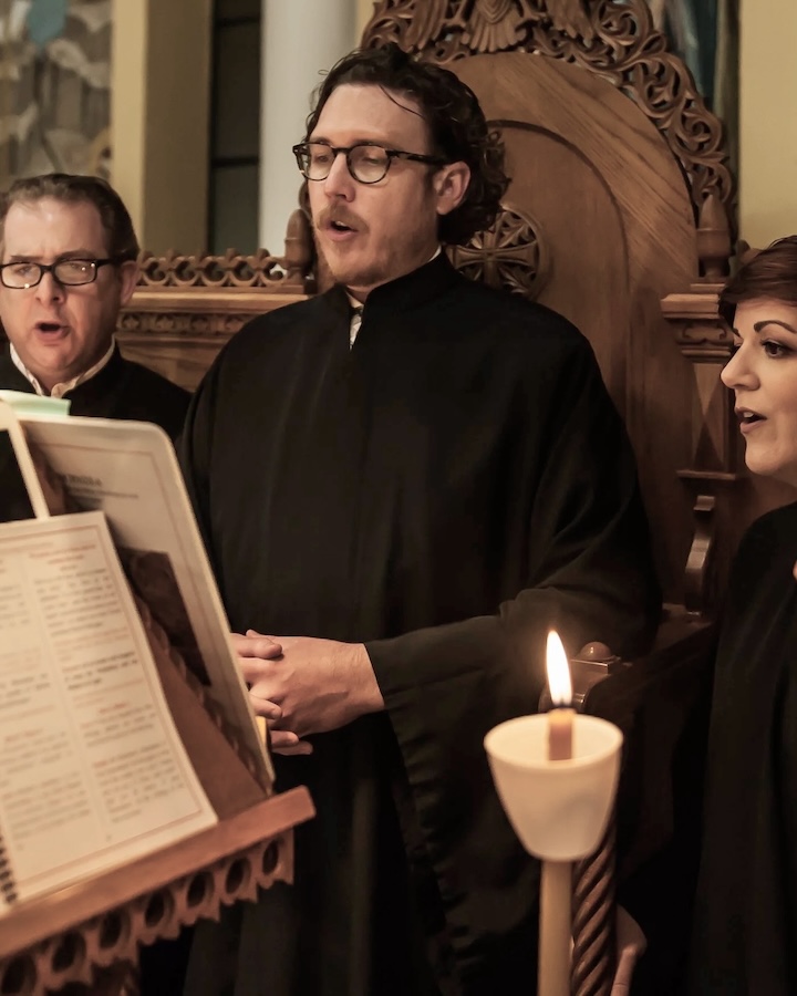Joshua Boyd chanting with the choir by candlelight